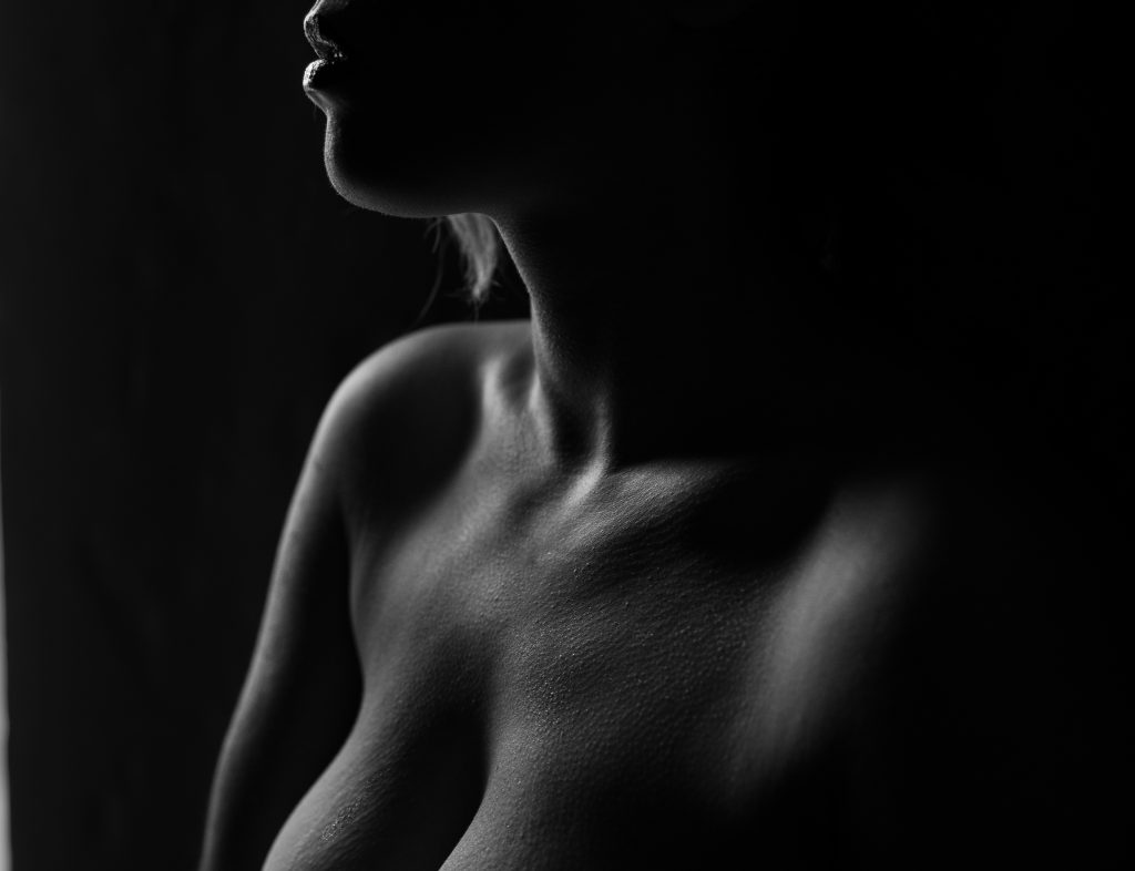 woman standing against black background contrasted with emphasized shoulders neck collar bones lips and cleavage Dijana Szewczyk photography Portland Oregon Boudoir Washington