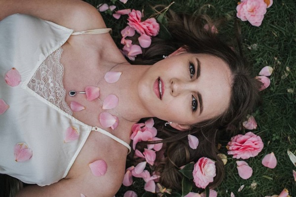 girl laying on grass, roses, brown eyes