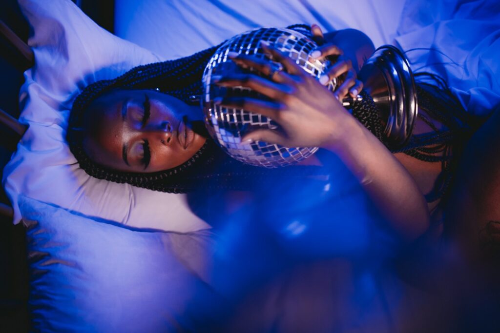 black girl laying down holding disco ball